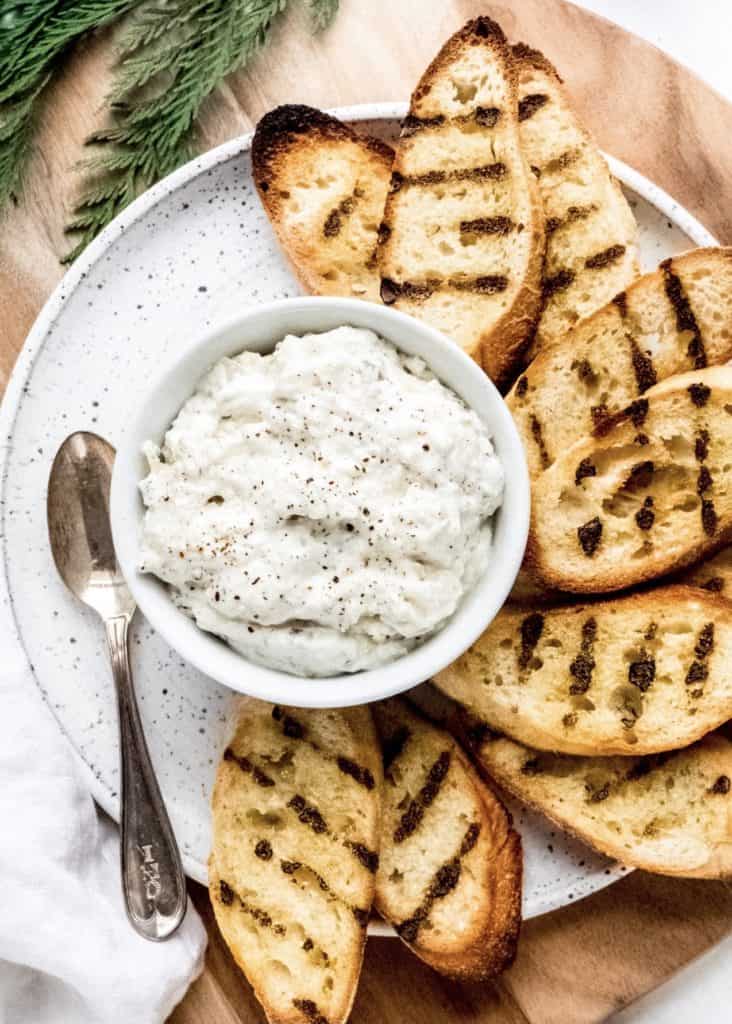 白色豆洋蓟蘸碗烤面包片包围